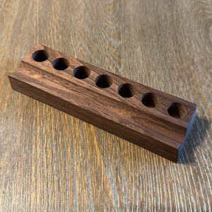 Wooden block with multiple holes on a wooden surface